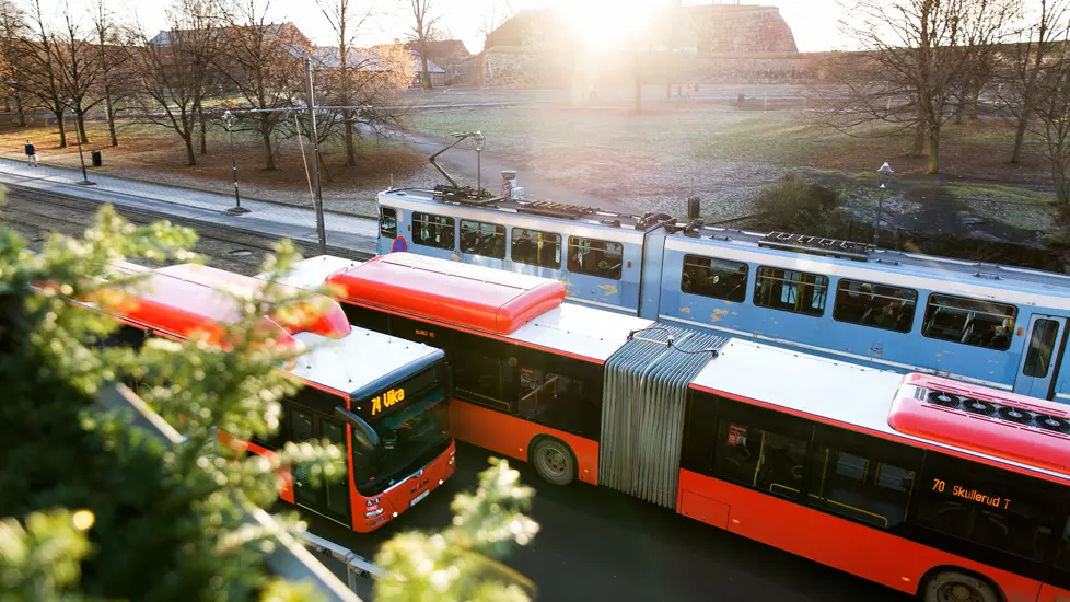 To busser og en trikk i trafikk i Oslo sentrum.