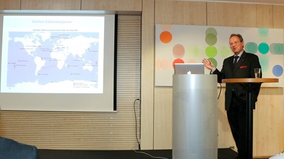Nasjonal ekspert Lars Giske står på podiet i konferansesalen i Norges hus og holder et foredrag om Galileo og EGNOS.