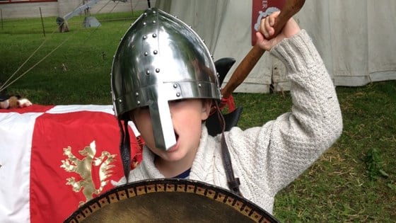 Et barn med hjelm og øks i Re middelalderfestival.