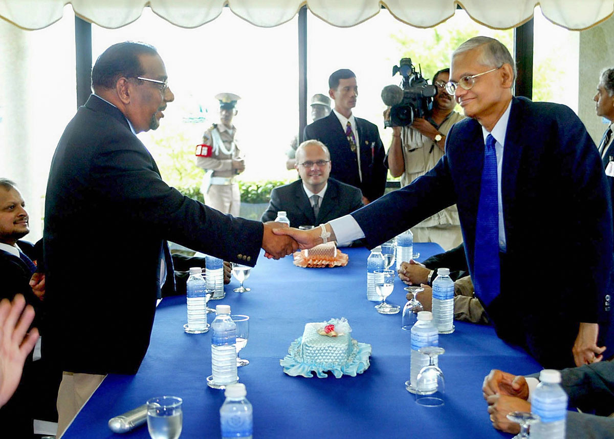 Figur 3.7 Grunnlovsminister og sjefsforhandler G.L. Peiris fra Sri Lankas myndigheter og sjefsforhandler Anton Balasingham fra Tamiltigrene hilser på hverandre, med Norges statssekretær Vidar Helgesen i rollen som tilrettelegger, under første runde med fredsfo...