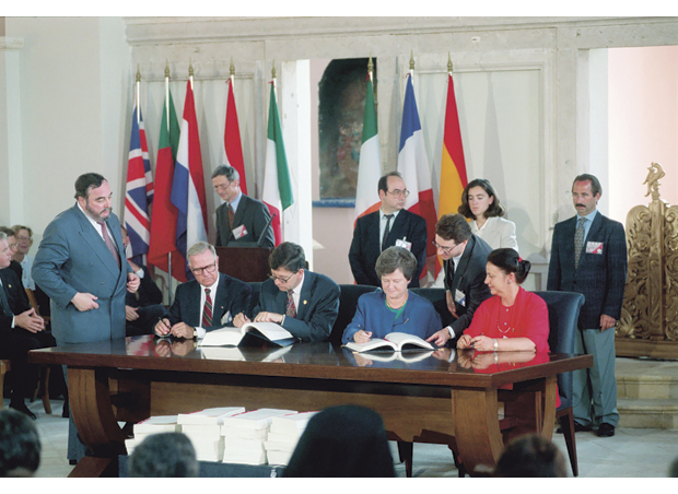 Figur 4.5 EØS-avtalen ble signert i mai 1992 i Porto, Portugal. Her ser vi fra venstre Eivinn Berg, utenriksminister Bjørn Tore Godal, statsminister Gro Harlem Brundtland og handelsminister Grete Knudsen. Foran skrivebordet ligger en stabel med alle vedleggene til EØS-avtalen.