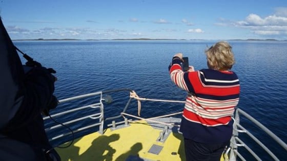 Statsminister Erna Solberg står på dekket av en båt på vei fra Tjøtta til Vega.