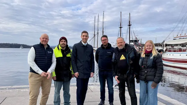 Seks personer på Honnørbrygga i Oslo. Båter i bakgrunnen.