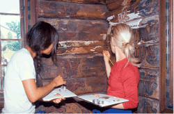 Figur 4.9 Konservering av museumsgjenstander og interiører krever nøyaktighet og tålmodighet. Her utbedres skader i Olav Hanssons dekorasjoner i Cappelen-stugu fra Telemark på Norsk Folkemuseum.