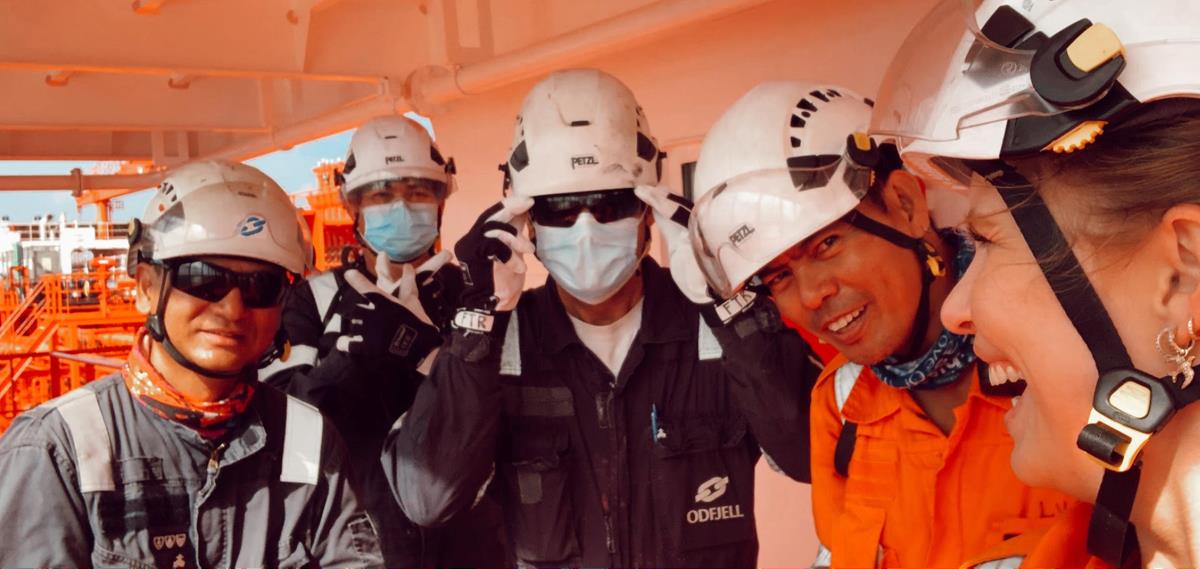 Five smiling seafarers wearing protective gear