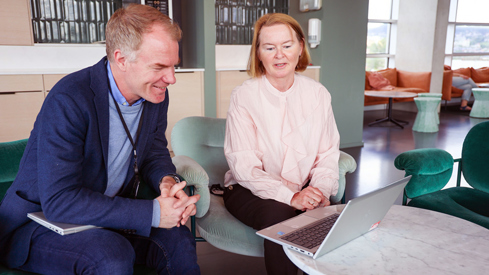 Illustrasjonsbilde av to ansatte i Helse- og omsorgsdepartementet i en fiktiv arbeidssituasjon