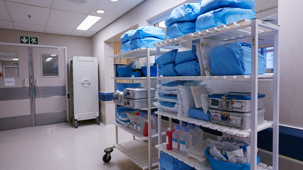 Medisinsk utstyr står på en reol i en sykehuskorridor