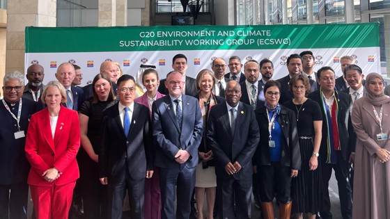 En gruppe med mennesker står foran et banner med teksten "G20 Environmental and climate sustainability working group"