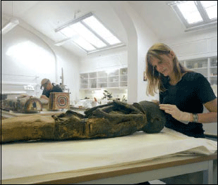 Figur 6.1 Universitetsmuseenes kunnskapsproduksjon er materielt basert.
 Her arbeider konservatorer ved Kulturhistorisk museum med en egyptisk
 mumie.