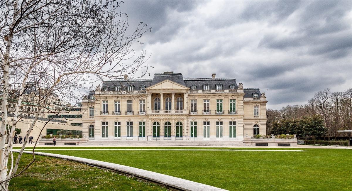 Bilde av Château de la Muette, OECDs hovedkvarter i Paris. En staselig bygning i beige sandstein, med skifertak, høye vinduer og søyler, bygget i 1920.