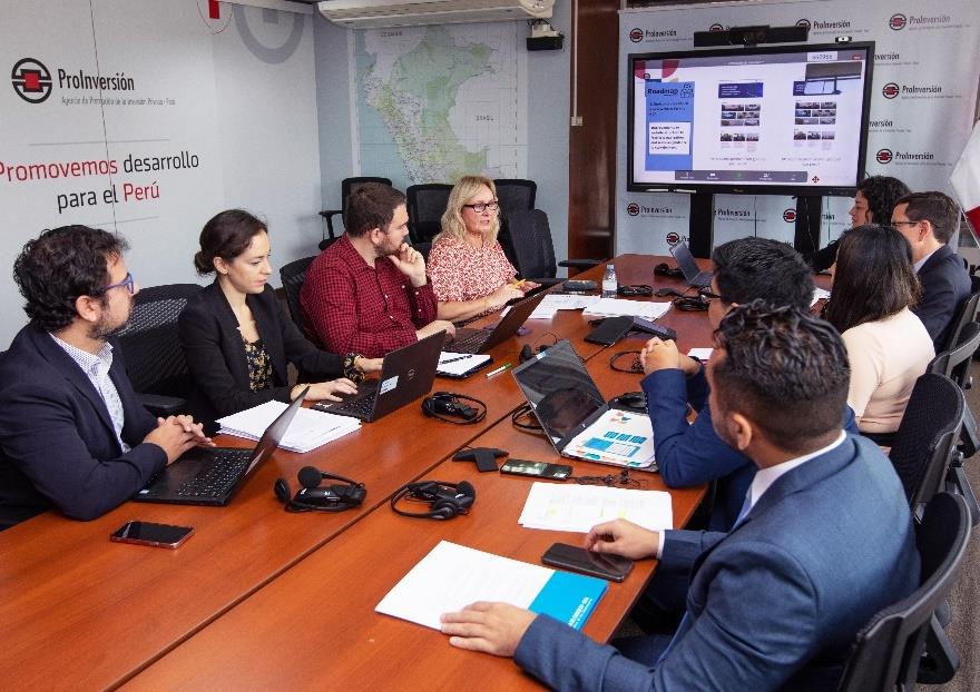 Partene samlet rundt et møtebord i et møterom, med en skjerm i bakgrunnen. Foto: Perus kontaktpunkt