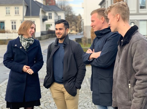 Forsknings- og høyere utdanningsminister Iselin Nybø står sammen med tre studenter ved Universitetet i Bergen. De har nylig kommet hjem før tiden fra et utvekslingsopphold i Hongkong.