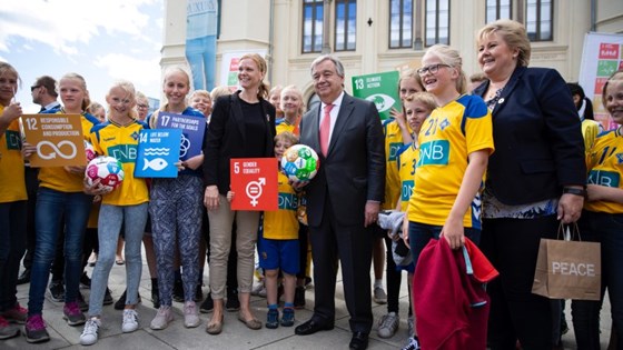 FNs generalsekretær António Guterres og statsminister Erna Solberg sammen med skolebarn foran Nobels Fredssenter i Oslo.