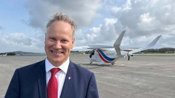 Samferdselsministeren foran elfly på rullebane.