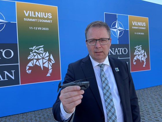 Forsvarsminister Bjørn Arild Gram holder opp en  modell av dronen i størrelsen 1:1