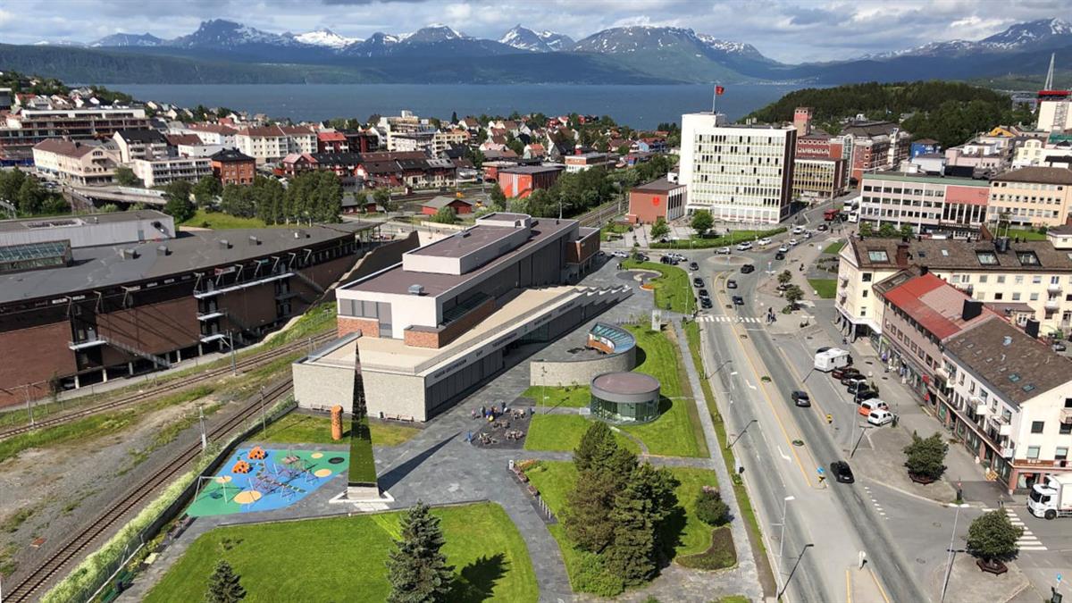 Oversiktsbilde av sentrum som viser nytt parkområde, rådhuset, fjorden og fjellene bak.