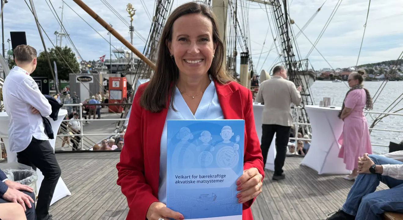 fiskeri- og havministeren med rapporten i hendene.