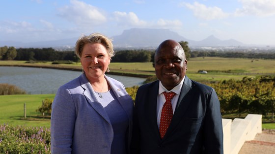 Bilde av utviklingsministeren møtte Sør-Afrikas helseminister som står ute med grønt gress i bakgrunnen