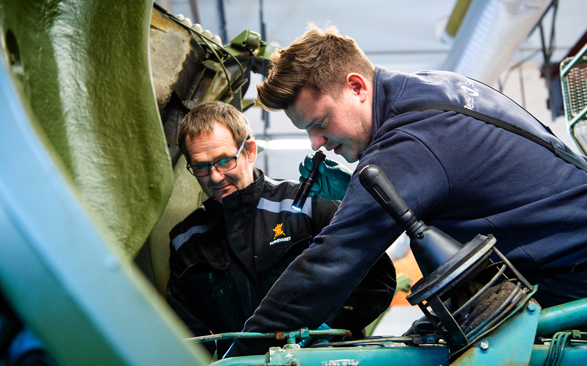 Figur 13.8 Sivil kompetanse er viktig for Forsvaret. En mekaniker fra Forsvarets verksted Østerdalen og en mekaniker fra Bertel O. Steen samarbeider om vedlikehold av et militært kjøretøy. 