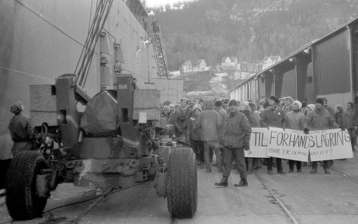Figur 2.5 18. desember 1983 ble amerikansk forsvarsmateriell brakt i land ved havnen i Hommelvika i Trøndelag. Mange mennesker hadde møtt frem for å demonstrere mot lossingen. På plakaten står det: «Nei til forhåndslagring. Hvor er demokratiet?»
