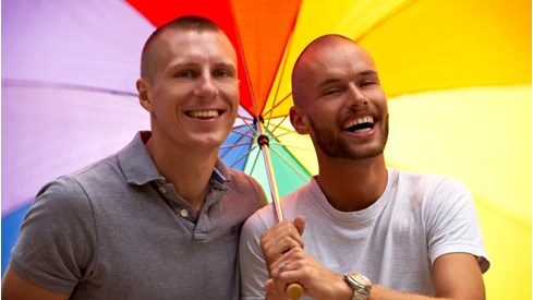 To menn som holder en paraply med regnbuefarger