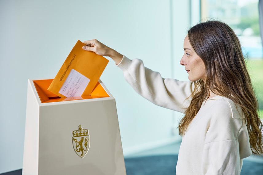 Foto som viser en velger som legger beredskapskonvolutten i urnen.