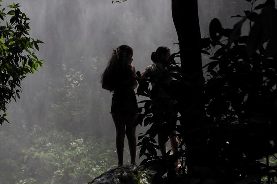 Urfolk ved en foss i tropisk skog i Brasil
