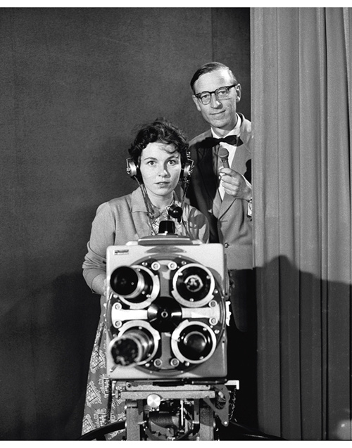 Figur 2.1 NRK fjernsynet starta sine sendingar 20. august 1960 og det var kong Olav som stod for den offisielle opninga. Etter opninga hadde fjernsynet ein rask ekspansjon i tilbodet. På biletet visast redaksjonssekretær Anders Buraas saman med assistent Eva J...