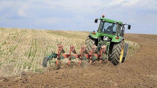 Traktor pløyer jord