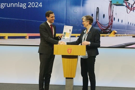 Klima- og miljøminister Andreas Bjelland Eriksen mottar rapporten fra Ellen Hambro, direktør for Miljødirektoratet