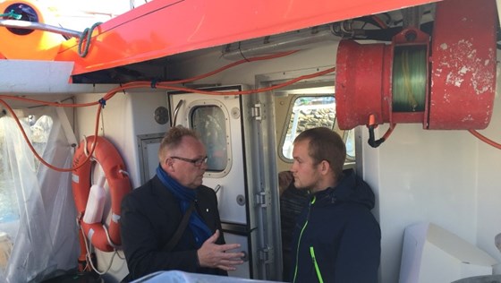 Fiskeriminister Per Sandberg i prat med fisker Magnus Olsen fra Skjervøy. Foto: NFD