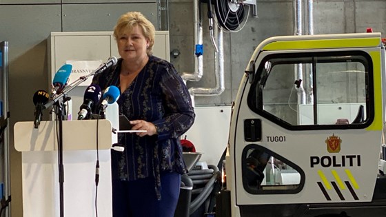 Statsminister Erna Solberg står ved talerstol i Det nasjonale beredskapssenteret på Taraldrud