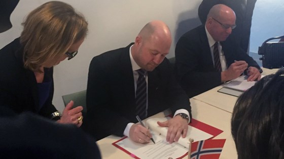 Justis- og beredskapsminister Anders Anundsen og statssekretær Fred Teeven signerer avtalen mellom Norge og Nederland. 