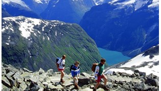 Tre personar går på fjelltur i Noreg