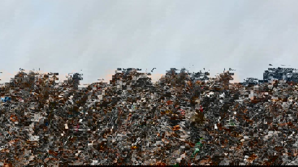 En haug med søppel foran en overskyet himmel.