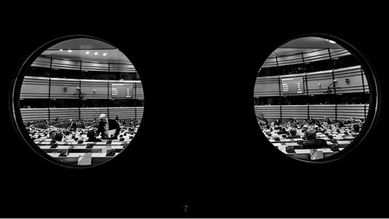 Svart/hvitt-bilde tatt gjennom døren og inn i plenumsalen i Europaparlamentsbygningen i Brussel.