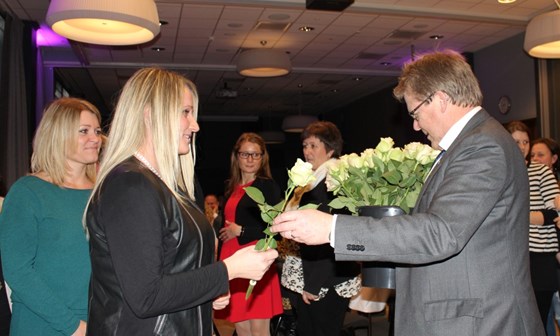 Ordfører Johnny Greibesland i Songdalen deler ut en rose til alle ansatte som har tatt teorikurs for fagbrevet. 