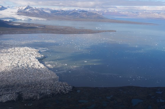 Flybilde av isbreer fjorder og fjell på Svalbard