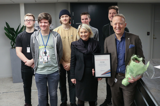 Statsbyggs direktør Harald Nikolaisen med diplom og blomster, sammen med kommunal- og moderniseringsminister Monica Mæland og 5 lærlinger