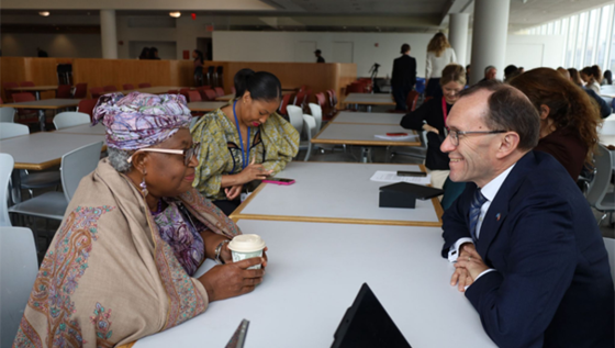 Mennesker sitter rundt et bord og snakker sammen.