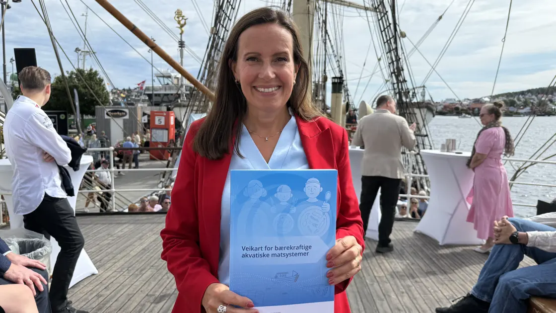 Fiskeri- og havministeren holder rapporten i hendene sine.