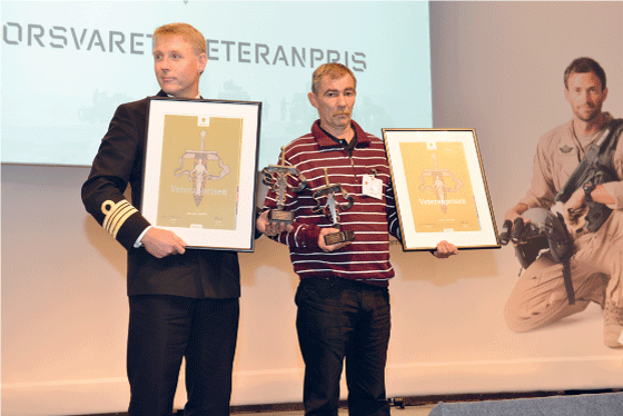 Figur 6.7 Forsvarets veteranpris ble første gang delt ut under Nasjonal veterankonferanse i Bergen i 2013. H.K.H. Kronprins Haakon overrakte prisen til daværende kommandørkaptein Jon Ivar Kjellin (t.v.) og T erje Sæterbø. 
