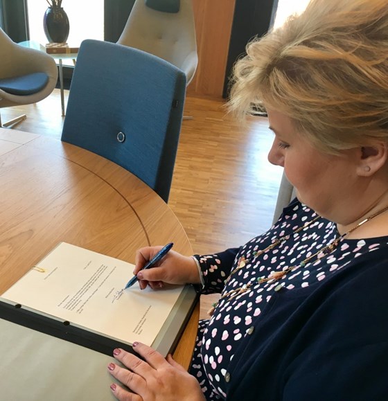 Statsminister Erna Solberg skriver under kondolansebrevet.