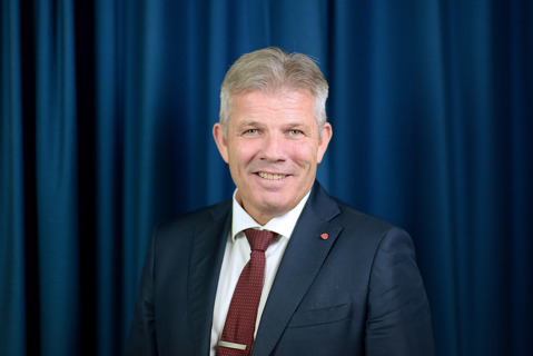 Portrett av statsråden med mørk blå bakgrunn