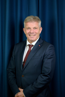 Portrett av statsråden med mørk blå bakgrunn