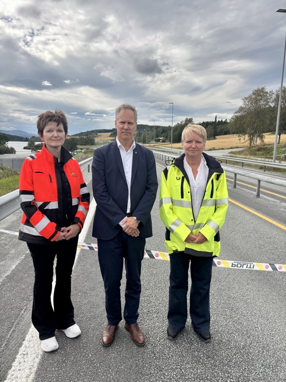 Tre personer oppstilt foran sperrebånd.