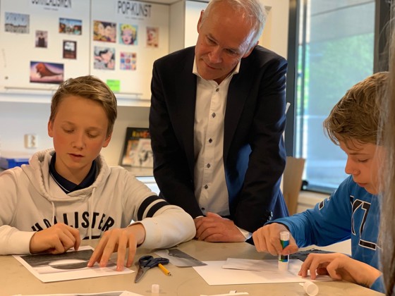 Bilde av Jan Tore Sanner som ser på at elever jobber