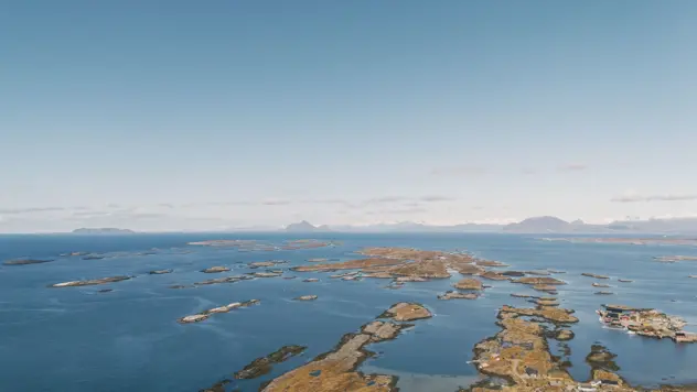 Hav og småøyer med fjell i bakgrunnen. Nord-norsk kystlandskap.