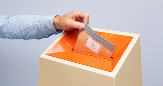 Illustrasjonsbilde med arm som slipper stemmeseddel ni en valgurne