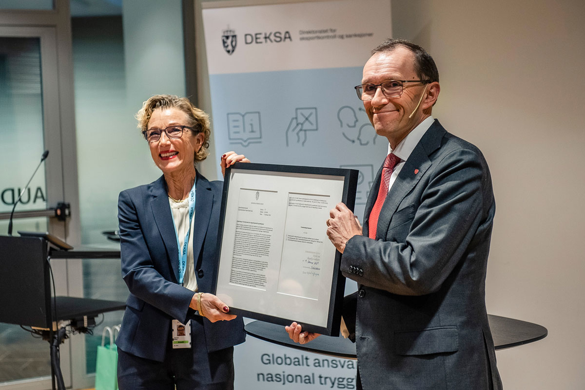 Figur 6.4 Utenriksminister Espen Barth Eide overleverte forvaltningsansvaret for eksportkontroll og sanksjoner til DEKSAs direktør, Harriet E. Berg, symbolisert i form av en innrammet utgave av den kongelige resolusjonen som 9. februar 2024 fastslo at direktor...